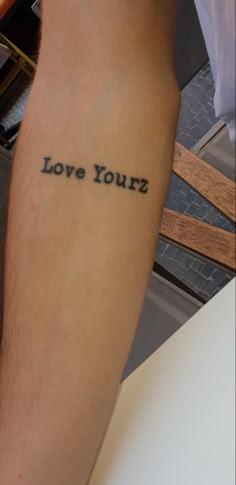 a man with a tattoo on his arm that says love yourz in black ink