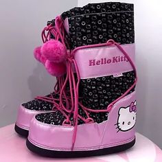 a hello kitty snow boot with pink pom - poms