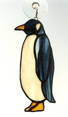 a glass penguin ornament hanging from a hook