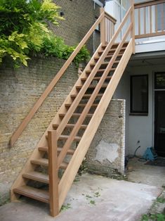 a wooden stair case next to a brick wall