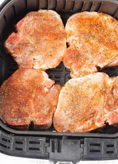 four raw pork chops in an air fryer