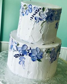 a three layer white cake with blue flowers on it