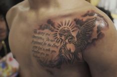 a man with a tattoo on his chest has an angel and bible written in it