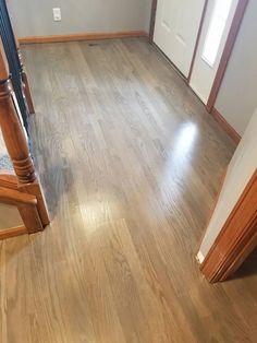 an empty room with wood floors and white walls, in the middle of a house