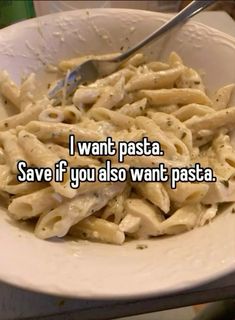 a white bowl filled with pasta sitting on top of a table