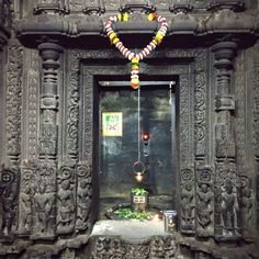 an ornate doorway with beads hanging from it's sides and decorations on the door