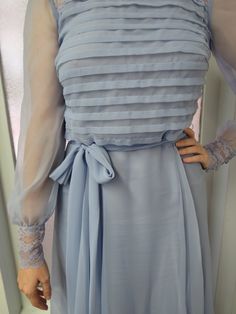 "Miss Elliette lilac/lavender/cornflower flowy maxi dress is super dreamy. Whether you are going to be vintage bridesmaid or you are going to a fall garden party, this dress has you covered. It is both romantic and very bohemian chic simultaneously. Sheer chiffon overlay gives this dress a beautiful draping effect. Top part of dress features a horizontal \"pleating\" with a gorgeous sheer lace collar that goes all the way around dress. Back is zippered with three buttons at nape. Sleeves are she Elegant Vintage Chiffon Dress For Spring, Elegant Chiffon Vintage Dress For Spring, Elegant Vintage Prom Dress For Spring, Elegant Lavender Maxi Dress With Ruffles, Spring Formal Vintage Maxi Dress, Elegant Lavender Chiffon Dress, Elegant Light Blue Maxi Dress For Garden Party, Spring Lavender Maxi Dress For Prom, Lavender Maxi Dress For Spring Prom