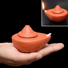 a hand holding an orange clay incense burner with a lit match between it and a black background