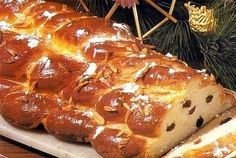 a loaf of bread sitting on top of a cutting board next to a christmas tree