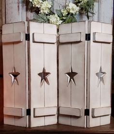 an old cabinet with flowers in it and some metal stars on the door knobs