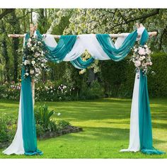 an outdoor wedding ceremony with blue and white draping, flowers and greenery