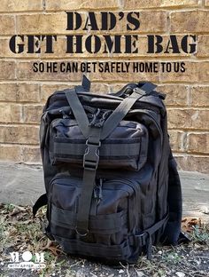 a black backpack sitting on the ground in front of a brick wall that says dad's get home bag