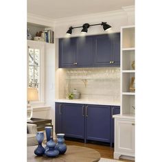 a kitchen with blue cabinets and white counter tops