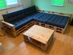 a living room with wooden pallets and blue couches on the hardwood flooring