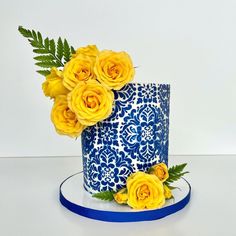 a blue and white cake with yellow flowers on top