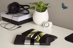 a white table topped with books and headphones next to a vase filled with flowers