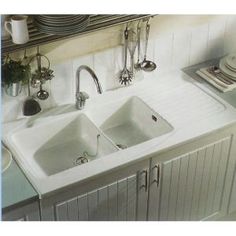 a kitchen with two sinks and plates on the counter