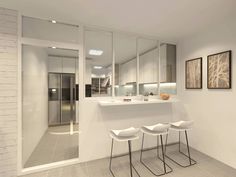 three white stools sit in front of a kitchen counter and mirror on the wall