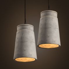 two concrete lamps hanging from a ceiling with lights in the middle and one light on each side