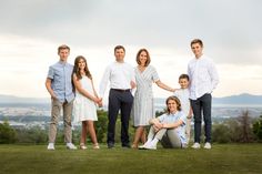 a family posing for a photo on top of a hill