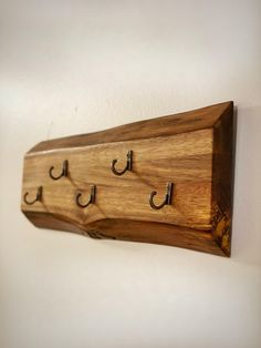 a wooden coat rack with three hooks on it