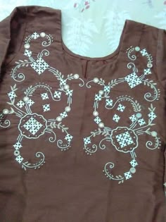 a brown shirt with white flowers on it