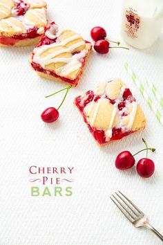 cherry pie bars with icing and cherries on a napkin next to a fork