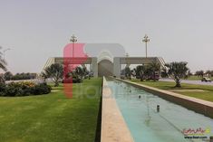 the water is running through the park in front of some palm trees and buildings with cars parked on it