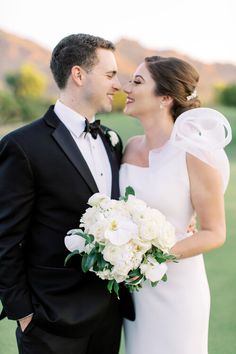 a bride and groom pose for a wedding photo in front of the golf course at sunset