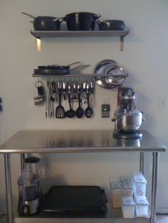 a stainless steel table topped with pots and pans