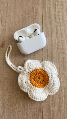 an earbud case with a crocheted flower attached to it