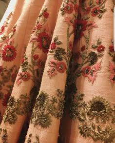 the curtains are decorated with red flowers and gold trimmings, along with green leaves