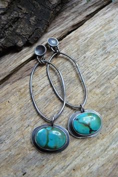 These stunning, natural blue-green turquoise earrings are set in and on sterling silver. They are a very bright blue-green with dapples of yellow, white and black. The natural gemstones measure close to 12x16mm and the overall measurement, from the top of the sterling concave ear wires to the bottom of the set earrings, are 2 3/4 inches and 3/4 inches wide. Each earring weights .2 oz or 6 grams. The silver has been oxidized and offered an industrial polishing. Shipping in the US includes trackin Blue Oxidized Dangle Jewelry, Southwestern Green Sterling Silver Earrings, Turquoise Oval Earrings With Natural Stones, Bohemian Turquoise Oval Earrings, Artisan Turquoise Earrings With Natural Stones, Artisan Turquoise Gemstone Earrings, Artisan Turquoise Sterling Silver Earrings, Oxidized Turquoise Oval Jewelry, Handmade Southwestern Oval Earrings