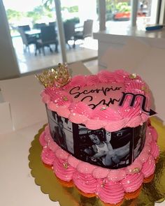 a birthday cake with pink frosting and a crown on top