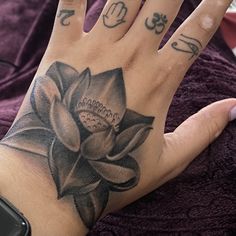 a woman's hand with a lotus tattoo on it