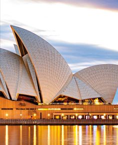 the sydney opera house is lit up at night