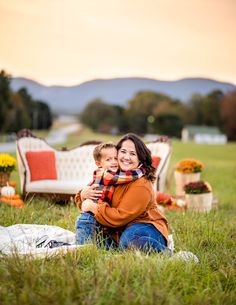 a woman and child sitting in the grass