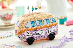 a small toy bus sitting on top of a table next to ribbons and other decorations