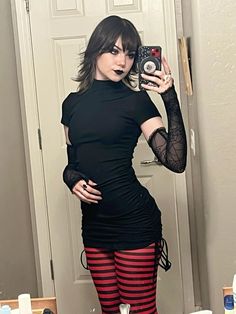 a woman taking a selfie in front of a bathroom mirror wearing tights and stockings