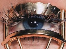 a woman's eye with long eyelashes and gold frames around her eyes, as if it were from scissor