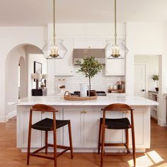 two stools sit at the center of a kitchen island