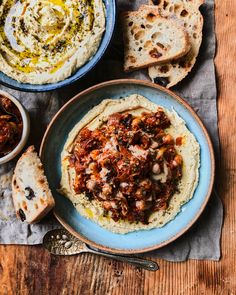 an image of hummus with bread and olives