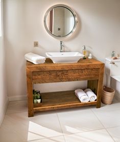 a bathroom with a sink, mirror and towel rack in it's center area