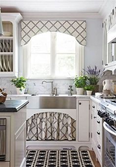 a kitchen with white cabinets, black and white rugs and an oven in the corner