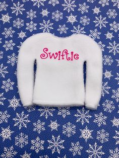 a white sweater with the word swiffie written on it and snowflakes