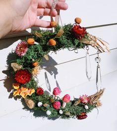 Handmade clay mushrooms, calcite crystals, dried flowers, moss, and glass sun catchers adorn this crescent moon wreath Moon Cottagecore, Dried Strawflowers, Moon Wreaths, Moss Mushroom, Crescent Moon Wreath, Painted Mushrooms, Pagan Christmas, Pagan Yule, Moon Wreath