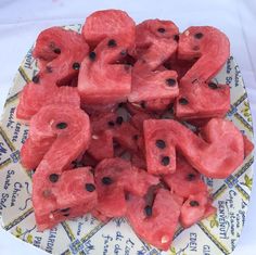 watermelon slices are arranged in the shape of numbers on top of a paper plate