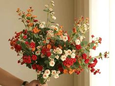 a person holding a bouquet of flowers in their hand