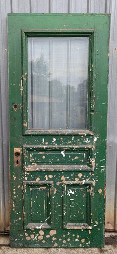 an old green door with peeling paint on it