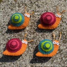 four snails with googly eyes sitting on the ground